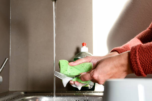 istock Woman hand washing dishes 1214284342