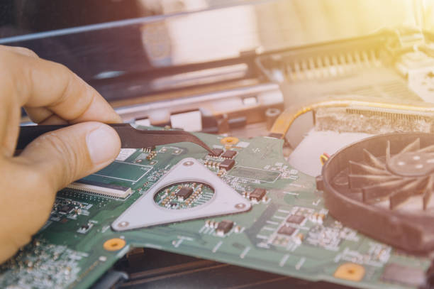 istock image technician repairing inside of Notebook by pliers Integrated Circuit. 1214288844
