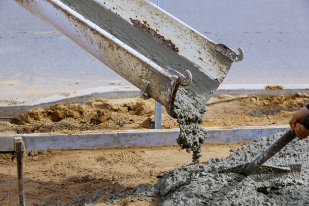 istock Construction worker pour cement for sidewalk in concrete works with mixer truck with wheelbarrow 1214289264