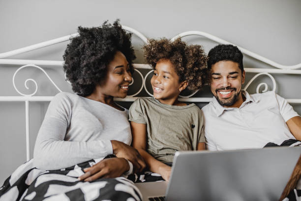 istock African American family using laptop in bed 1214289501