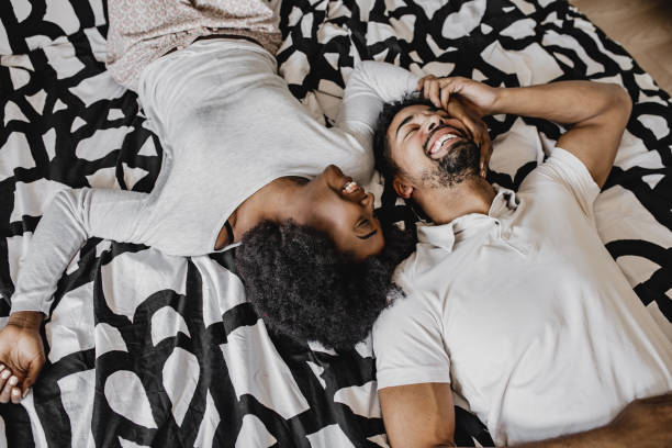 젊은 커플 포옹 에 침대 - sexual activity black couple african descent 뉴스 사진 이미지