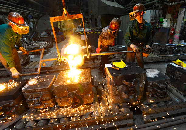 istock workers in a foundry casting a metal workpiece - safety at work and teamwork 1214290717
