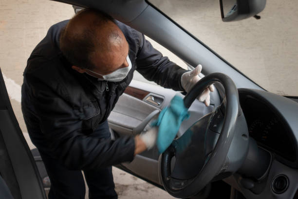 Middle aged Turkish man disinfects his car stock photo