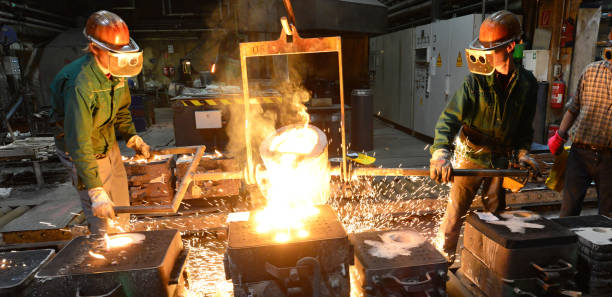istock workers in a foundry casting a metal workpiece - safety at work and teamwork 1214290888