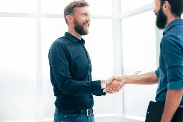 istock business people shaking hands in a bright office 1214290959
