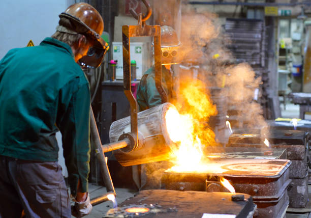 istock workers in a foundry casting a metal workpiece - safety at work and teamwork 1214291315