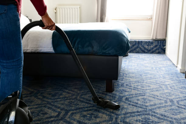 istock Woman vacuuming bedroom carpet 1214291452