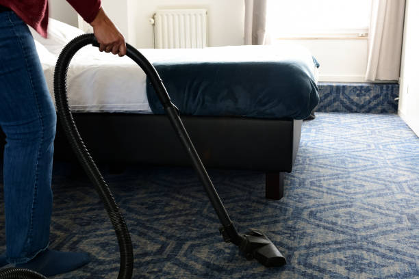istock Woman vacuuming bedroom carpet 1214291457