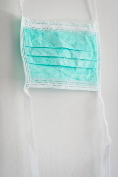 istock Surgical medical face mask as individual protection device. 1214293452