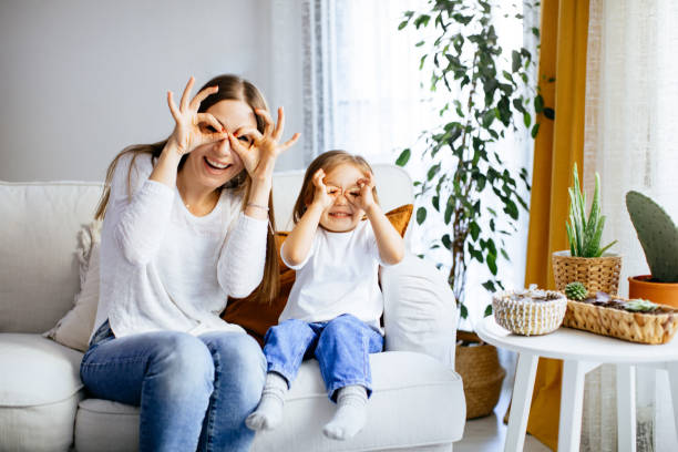 istock Mother and her daughter sitting on comfortable couch at home 1214294934