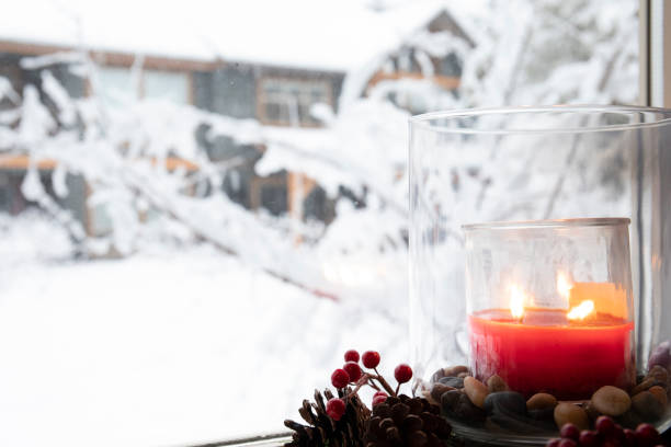 istock Christmas candle burns on windowsill inside house 1214295620