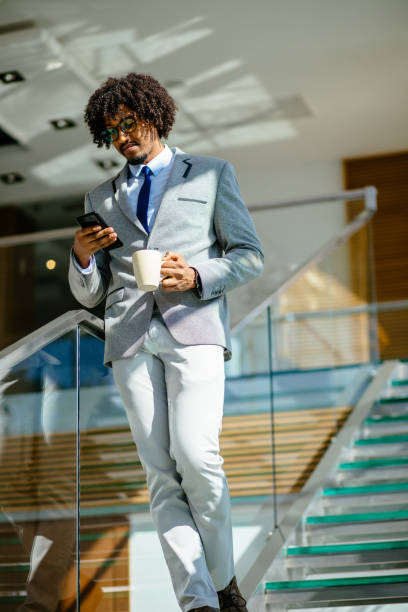 istock Young African American businessman using mobile phone on staircase 1214295627