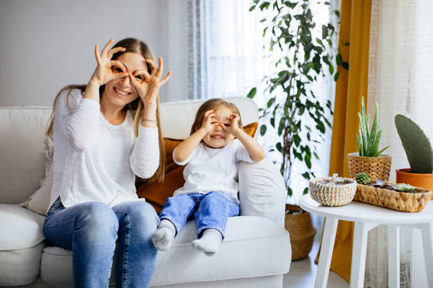 istock Mother and her daughter sitting on comfortable couch at home 1214297715