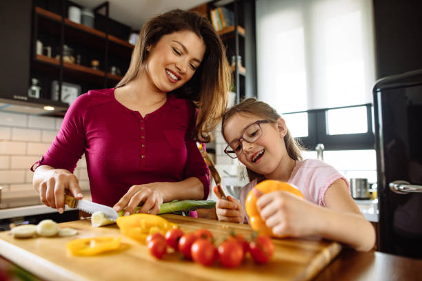 istock Mother and daughter cutting vegetable in the kitchen 1214297970