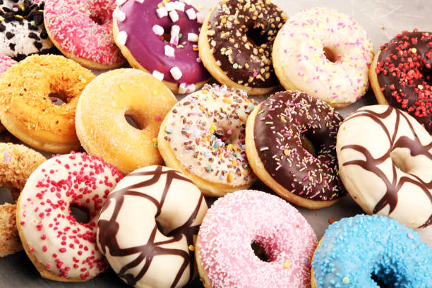 istock assorted donuts with chocolate frosted, pink glazed and sprinkles donuts 1214299279