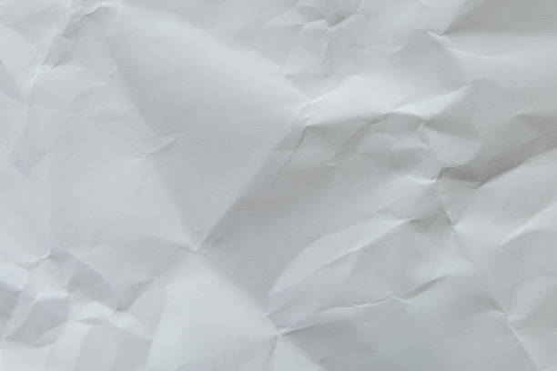 istock Wrinkled white blank plain paper with shade of light and shadow. Ideal for background or wall wallpaper with copy space for text. 1214299639