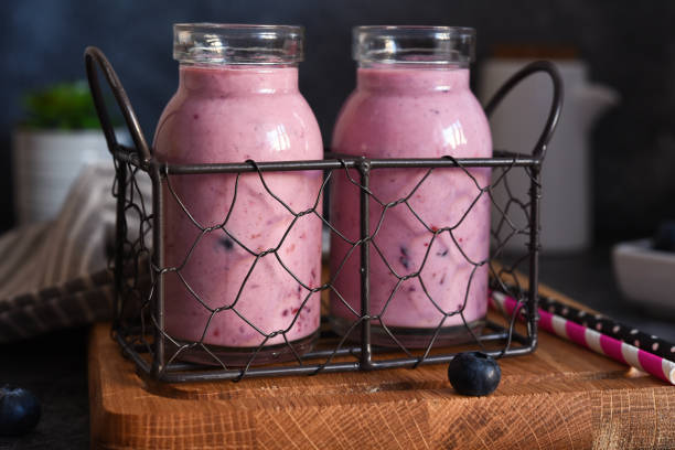 detox drink. smoothies with blueberries and yogurt in a glass jar on the kitchen table. - strawberry blueberry raspberry glass imagens e fotografias de stock