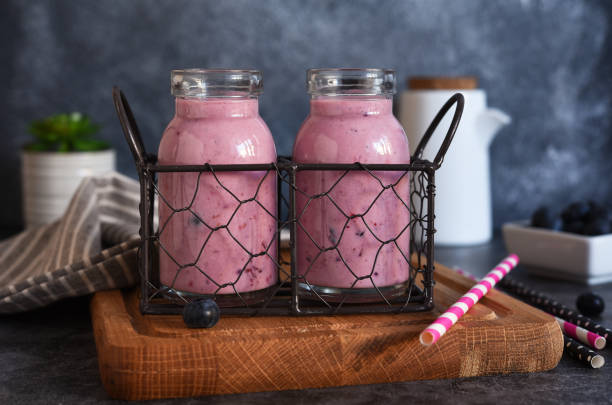 detox drink. smoothies with blueberries and yogurt in a glass jar on the kitchen table. - strawberry blueberry raspberry glass imagens e fotografias de stock