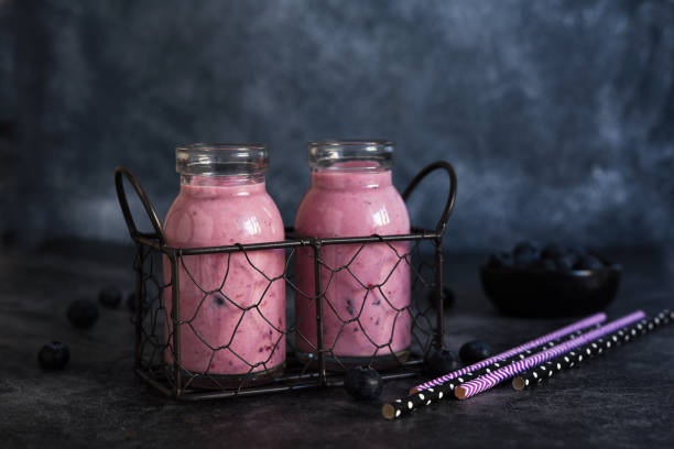 detox drink. smoothies with blueberries and yogurt in a glass jar on the kitchen table. - strawberry blueberry raspberry glass imagens e fotografias de stock