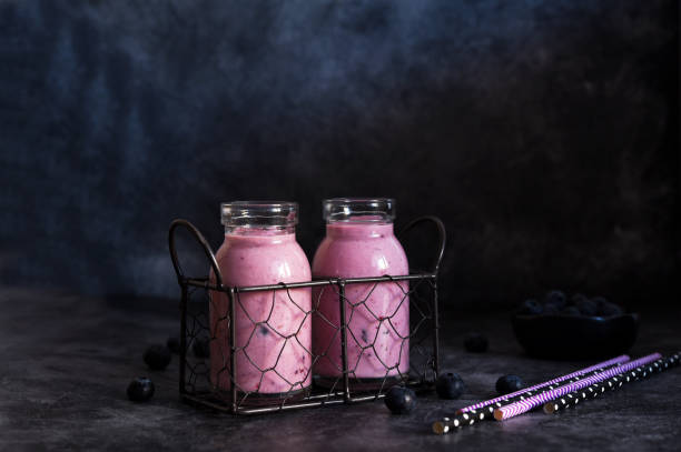 detox drink. smoothies with blueberries and yogurt in a glass jar on the kitchen table. - strawberry blueberry raspberry glass imagens e fotografias de stock