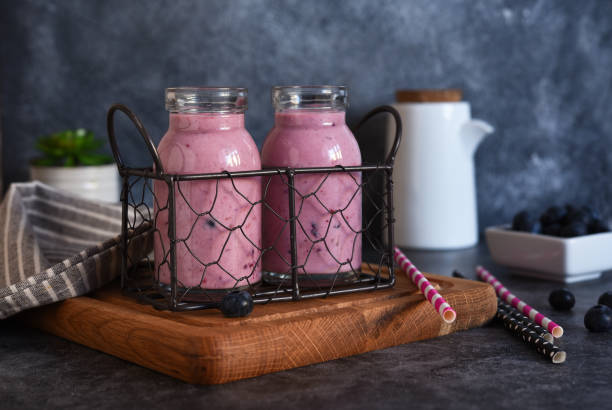 detox drink. smoothies with blueberries and yogurt in a glass jar on the kitchen table. - strawberry blueberry raspberry glass imagens e fotografias de stock