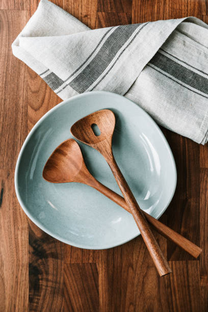 istock Empty ceramic plate for salad with wooden kutchen tools on a wooden table. Eco style home still life, top view. 1214302105