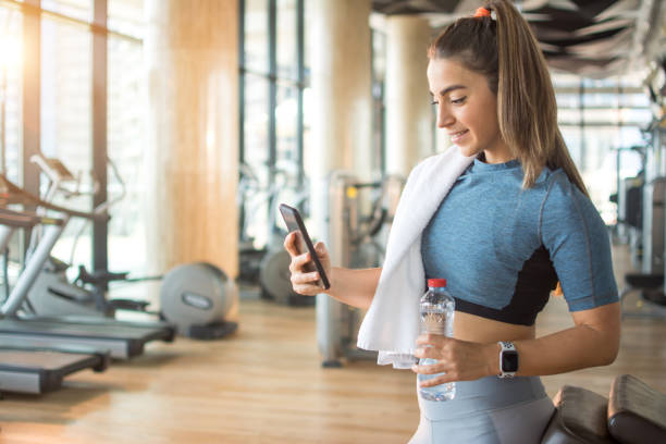 istock Active girl using smartphone in fitness gym. 1214302121