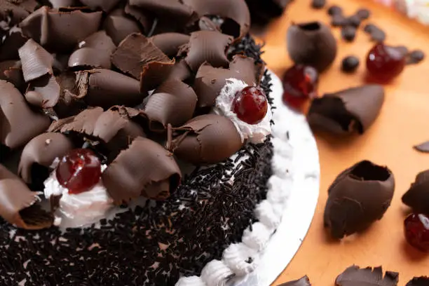 Chocolate cake with whipping cream and cherry topping with grated chocolates