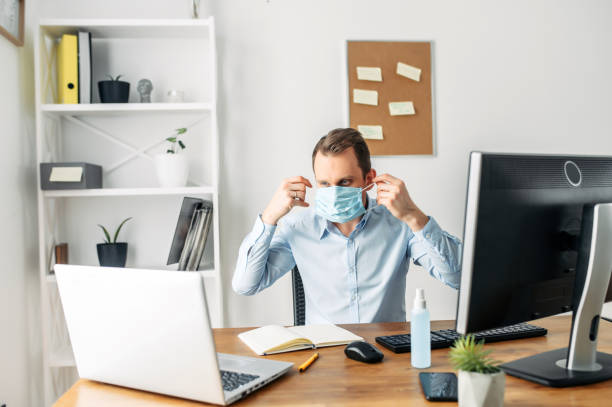 istock Man in a medical mask at the office 1214310570