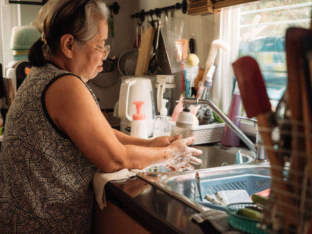 istock Senior hands rubbing and washing her hands 1214311519