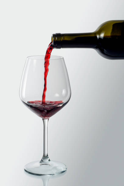 istock Bottle pouring red wine into an elegant glass 1214313798