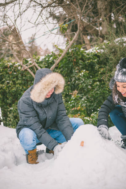 istock boy and girl playing with snow 1214315703