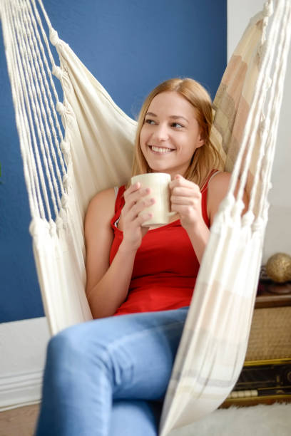 istock woman with cup sitting in hammock 1214317568