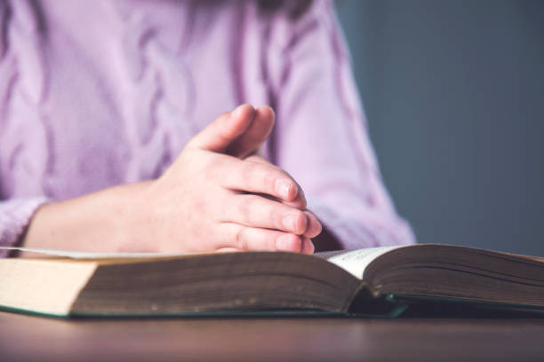 istock prayer woman hand on Bible 1214318910