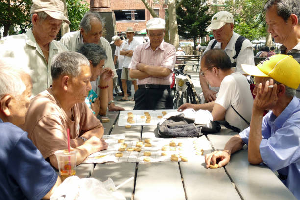 hommes supérieurs chinois jouant des échecs chinois dans le stationnement - chinese chess leisure games chinese culture traditional culture photos et images de collection