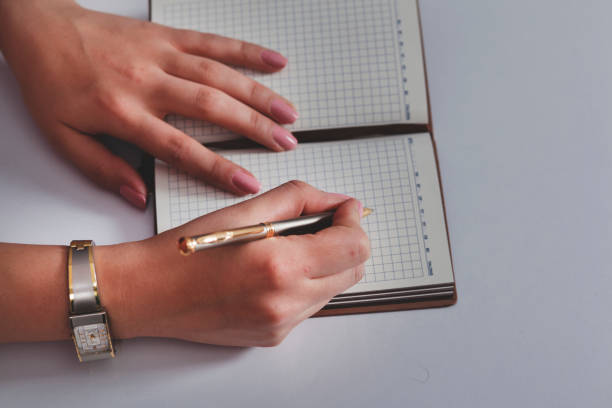istock woman hand pen with notepad on the working desk 1214319639