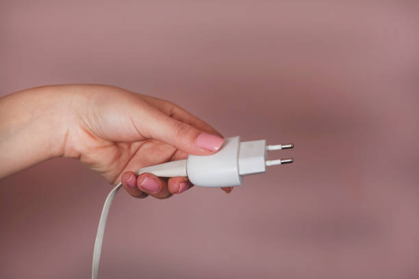 istock woman hand holding phone charger 1214319790