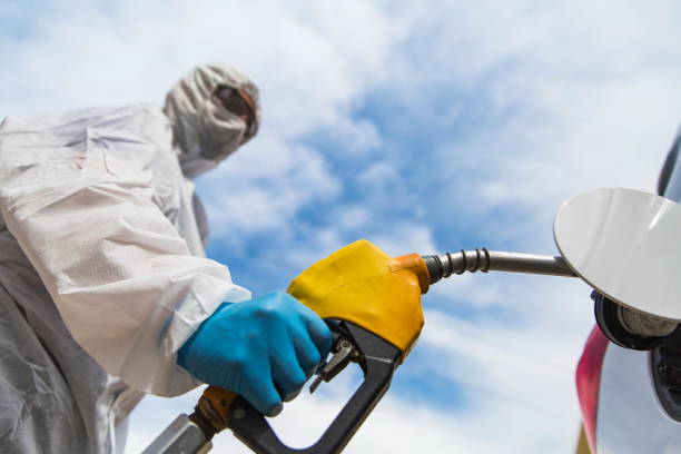Gas station worker refilling car at service station