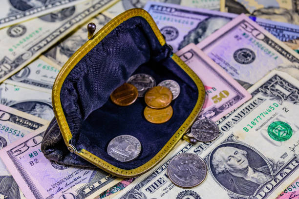 istock Old wallet with american cent coins over the dollar banknotes 1214321015