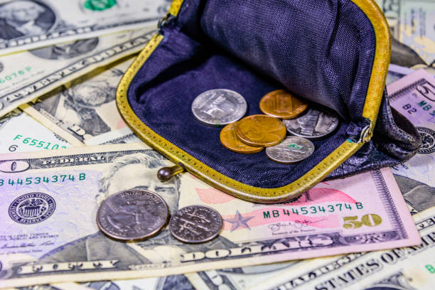 istock Old wallet with american cent coins over the dollar banknotes 1214321019