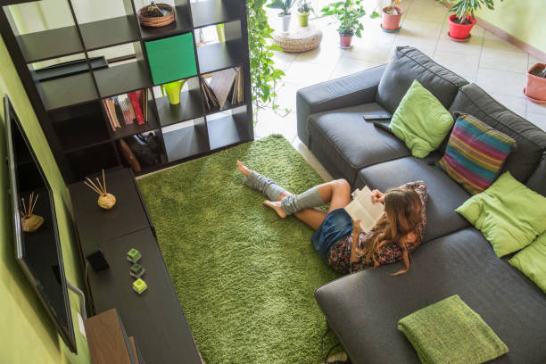 woman reading a book on a carpet stock photo