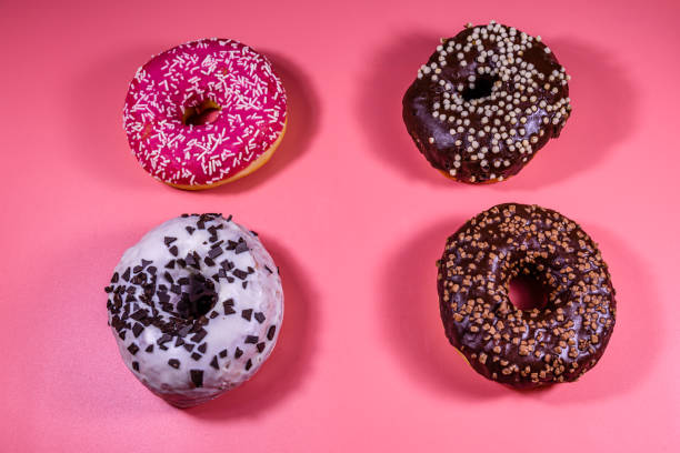 istock Fresh glazed donuts isolated on a pink background 1214321125