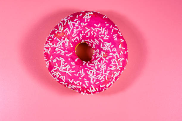 istock Donut with glazed top isolated on a pink background 1214321127