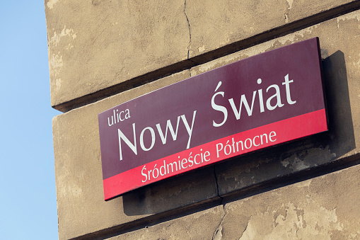 Nowy Świat street sign on a building in downtown Warsaw, a street which is a popular tourist destination with many shops, restaurants and cafes.