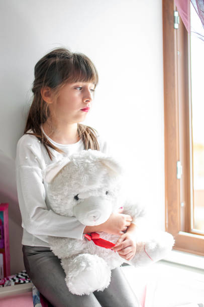 istock Cute girls boring at home with her teddy bear 1214322690