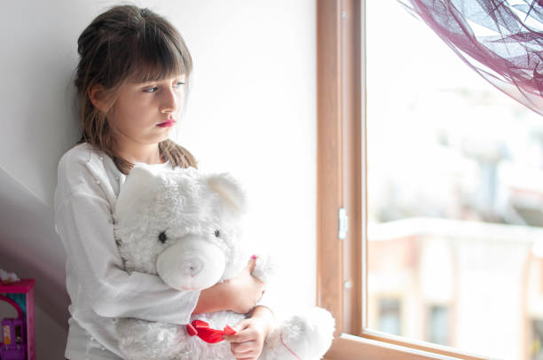 istock Cute girls boring at home with her teddy bear 1214322913