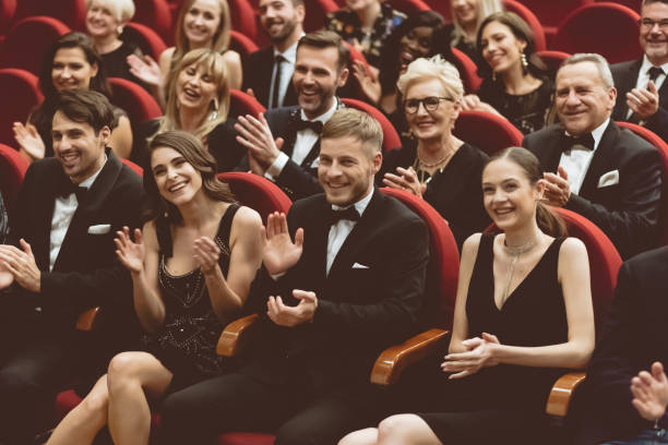 Elegant spectators clapping in the theater Smiling audience clapping in opera house. Men and women are watching theatrical performance. They are in elegant wear. classical concert photos stock pictures, royalty-free photos & images