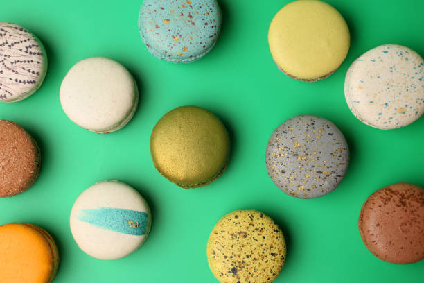 Colorful french macaroons on green background