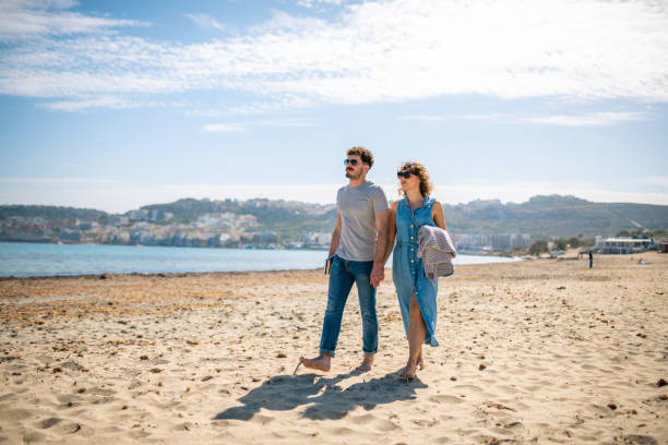 istock Heterosexual couple walking on the beach and holding hands 1214324340