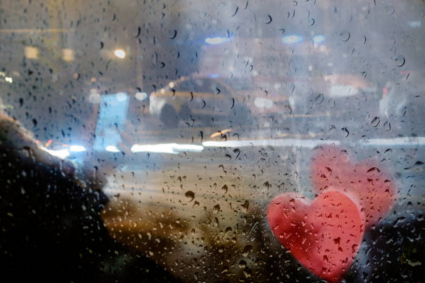 istock Using smartphone in city, view through wet glass 1214324881